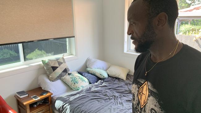 Lionel Etoundi surveys the personal items his son Alane Etoundi left behind when he went for a walk to the beach at Lennox Head. Alane drowned after getting into trouble while swimming at the beach.