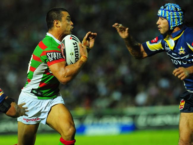 Craig Wing looks to break a tackle from Johnathan Thurston while playing for the Rabbitohs.