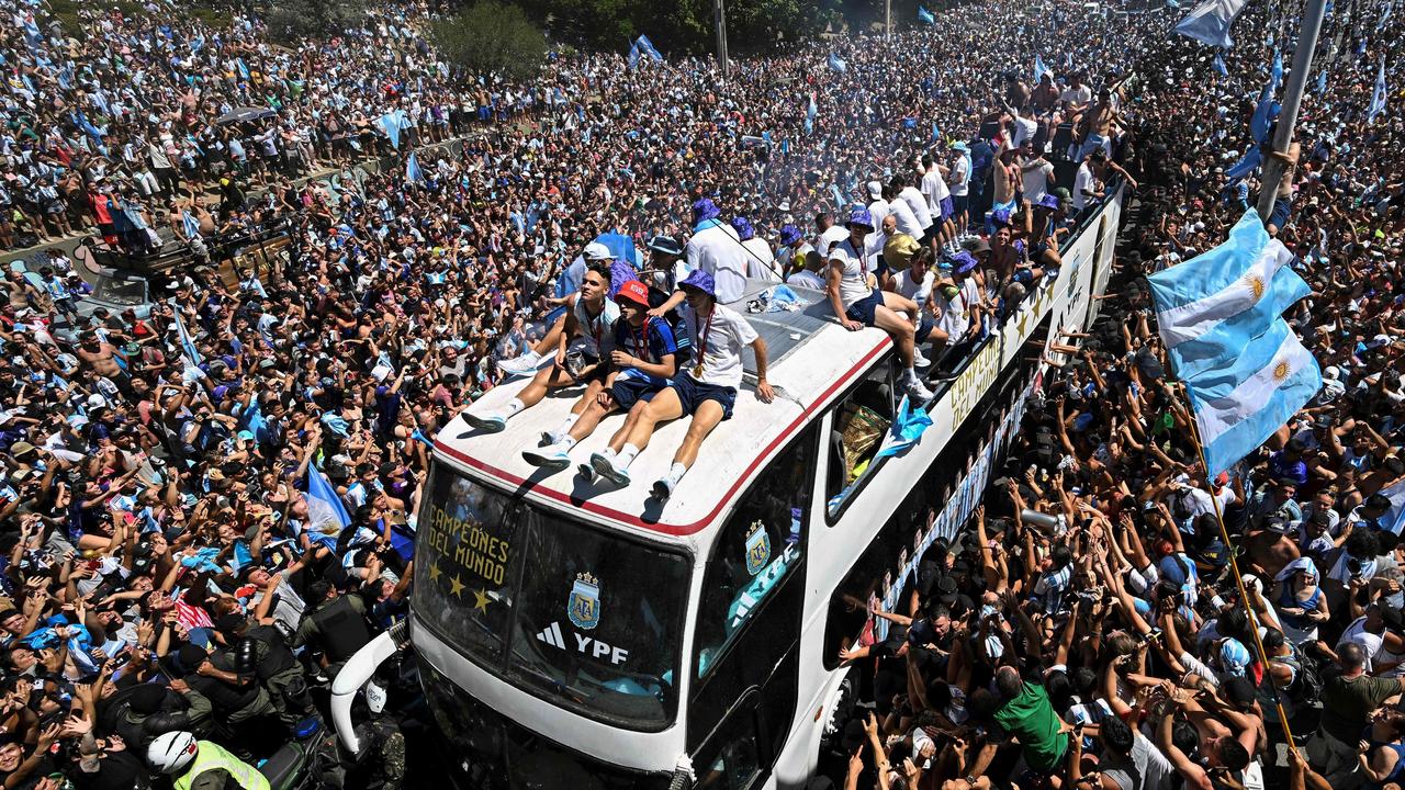 Fans of Argentina cheer as the team passes by. Photo by Luis ROBAYO / AFP.