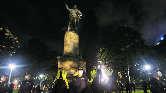 NSW police guard the statue of Captain James Cook in Sydney’s Hyde Park on Friday. Picture: Getty Images