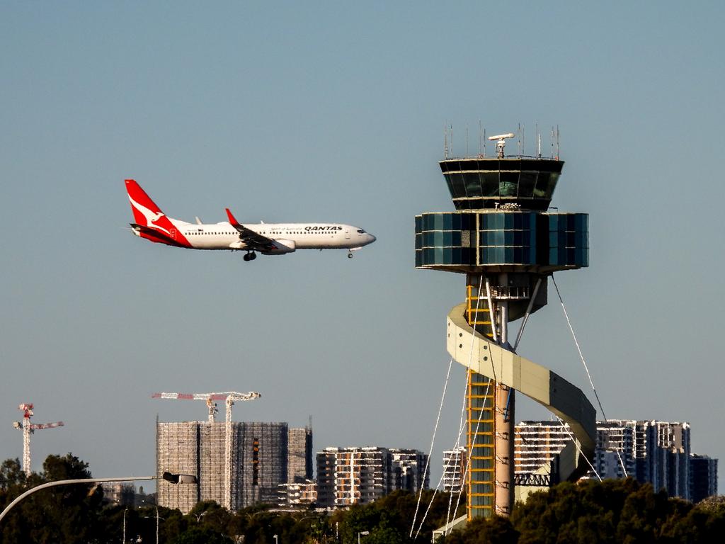 A Qantas B737-838 plane, registration VH-VXU, coming into land on the third runway of Sydney Kingsford-Smith Airport as flight QF579 from Hamilton Island.  In the foreground is the air traffic control tower.  This image was taken from Kyeemagh Avenue, Kyeemagh on a sunny winter afternoon on 10 June 2023.Escape 13 October 2024Doc updatePhoto - iStock