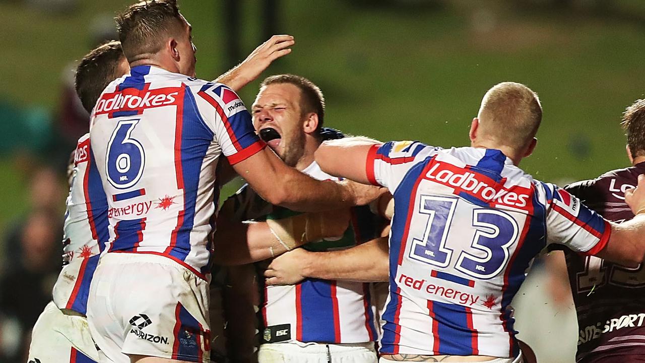 Nathan Ross of the Knights celebrates scoring a try with team mates.