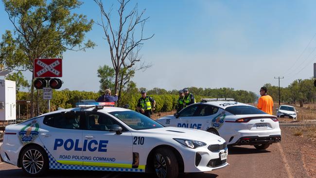 Police vehicles form a blockade at the scene of a bushfire that ripped through the Livingstone area this afternoon, threatening local properties. Picture: Che Chorley