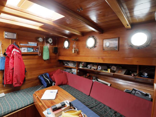 The spacious area below deck on Juliene features rich timber panelling and porthole windows. Picture: Richard Jupe