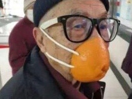 An elderly man sports and orange peel and string mask at Beijing airport. Picture: Weibo