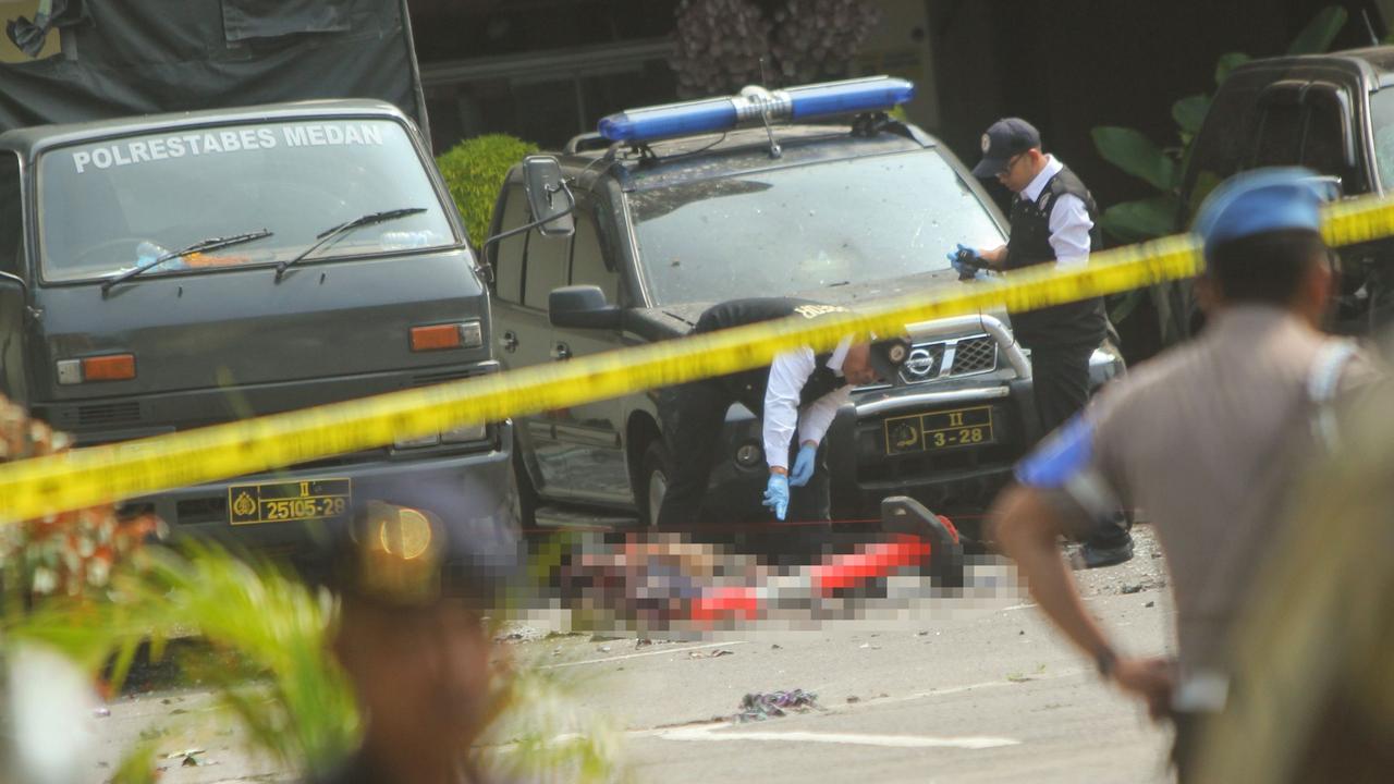 Indonesian police examine the body of a suspected suicide bomber at their headquarters in Medan. Picture: ATAR / AFP