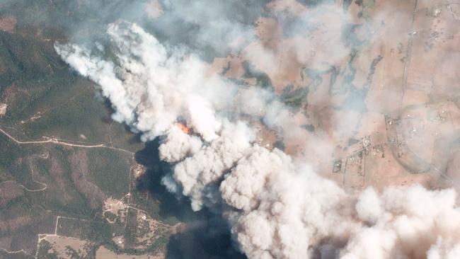 A satellite image from Planet Labs Inc shows smoking rising into the air from bushfires near Lake Conjolia. Picture: AFP