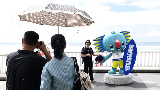 International tourists take photographs with Commonwealth Games Mascot Borobi the Koala at Broadbeach on the Gold Coast, Friday, March 30, 2018. (AAP Image/Dave Hunt)