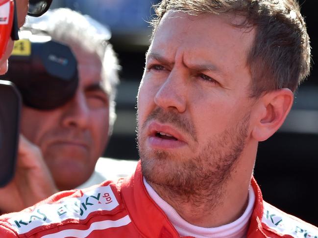 Ferrari's German driver Sebastian Vettel (R) talks with his team staff before the start of the Formula One Japanese Grand Prix at Suzuka on October 8, 2017.  / AFP PHOTO / Kazuhiro NOGI