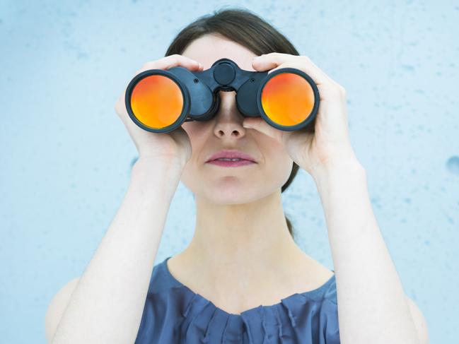 Business vision: woman holding binoculars. istock