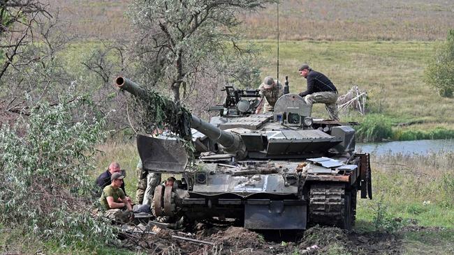 Ukrainian servicemen work on a tank abandoned by Russian troops during their retreat in the north of the Kharkiv region. Chips made by a UK semiconductor manufacturer were found in a tank abandoned near Kyiv. Picture: AFP