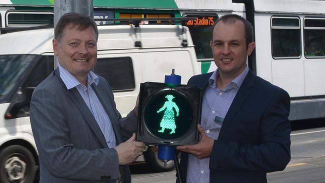 Supplied image obtained Tuesday, March 8, 2016 of City of Yarra Mayor Roberto Colanzi (left) and Director of Metropolitan Projects Central Brendan Pauwels with a silhouette of a 1920s woman on a crossing signal in Melbourne. The woman, Mary Rogers, was the first woman elected to a Victorian council and her image will replace the red and green crossing figure on a new crossing in Richmond. (AAP Image/VicRoads) NO ARCHIVING, EDITORIAL USE ONLY