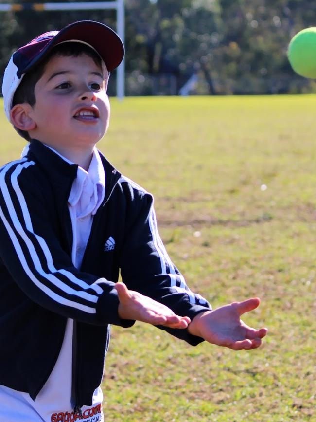 A boy playing catch at a sport birthday party.