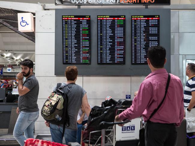 Passengers check the board shows status of flights at the country's largest airport, Istanbul Ataturk, following yesterday's blast. Picture: Getty