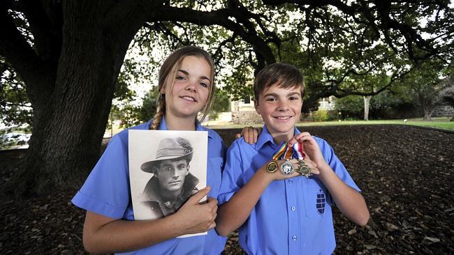 Maddison Hines, 14, and her brother Mitchell Hines, 13, hold medals and a picture of thei