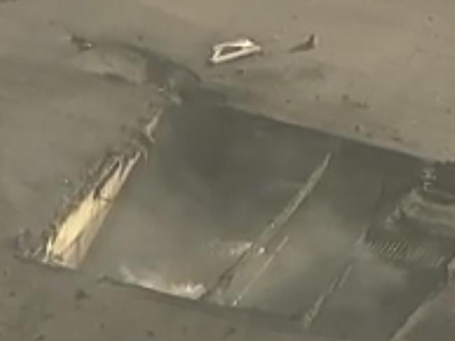 A gaping hole is left in the warehouse after the plane crash. Picture: KABC-7 / AP