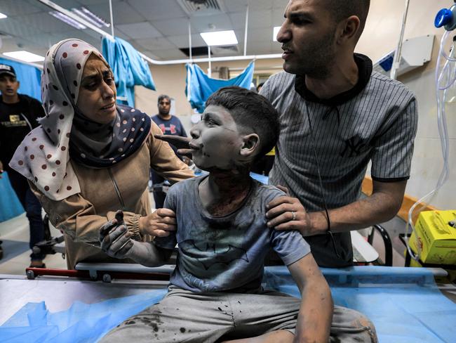 A woman and a man attend to a child injured in Israeli bombardment while awaiting treatment at a trauma ward at Nasser hospital in Khan Yunis in the southern Gaza Strip. Picture: AFP