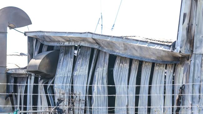 NTFES Firegighters douse the remaining smouldering ruins of a Business Fire overnight Picture: Glenn Campbell