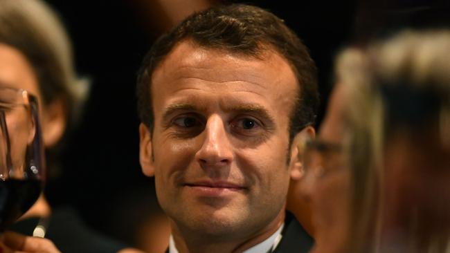 France's President Emmanuel Macron raises  glass in a toast during a dinner in his honour at the Sydney Opera House in Sydney on May 1, 2018.  Macron arrived in Australia on May 1 on a rare visit by a French president with the two sides expected to agree on greater cooperation in the Pacific to counter a rising China. / AFP PHOTO / POOL / MICK TSIKAS