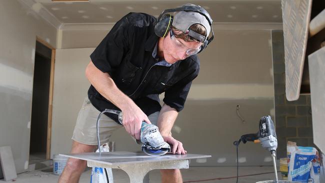 Demand for new houses in Cairns is at such high levels that workers are being treated to added benefits to stick with their employer. Fourth year apprentice tiler for Bridgewater Homes Dale Harris-Smith cuts some bathroom tiles for a new house being built in the Cherrybrook Estate in Bentley Park. Picture: Brendan Radke