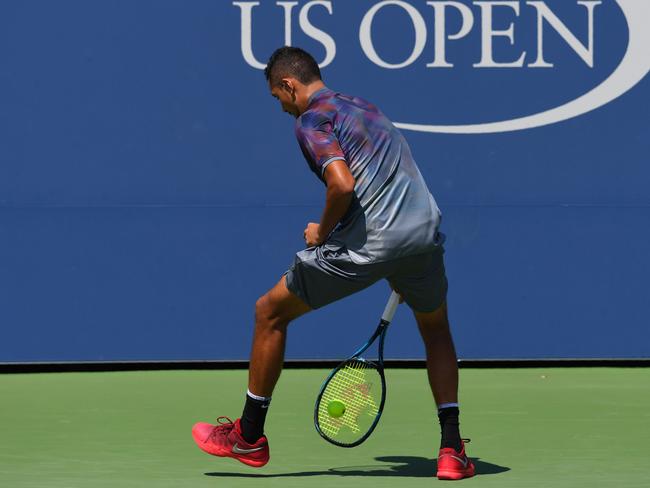 Nick Kyrgios returns the ball in typically unorthodox style.