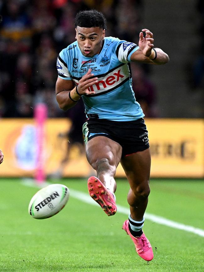 Ronaldo Mulitalo of the Sharks puts a kick through against Brisbane. Photo by Bradley Kanaris/Getty Images.