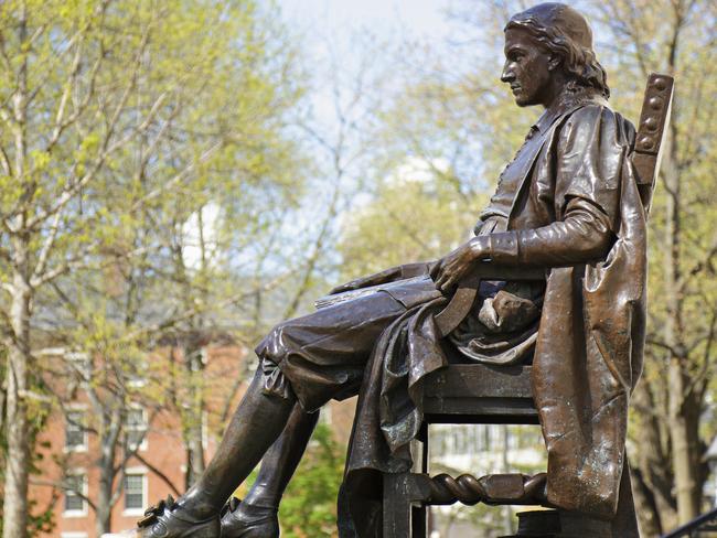 Jon Harvard monument with Harvard campus in background, Boston, US. iStock