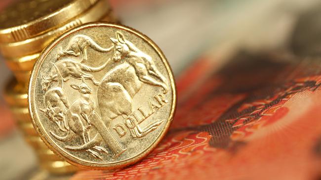 Australian one dollar coin sitting on a twenty dollar note. Shallow depth of field. Picture: istock