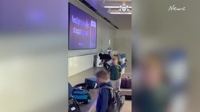 Minor going through baggage carousel at Canberra Airport