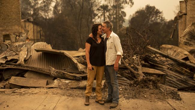 Sally Wilson and her partner Christopher Lee in front of her destroyed Cobargo shop in January 2020. Picture: AAP Image/Sean Davey