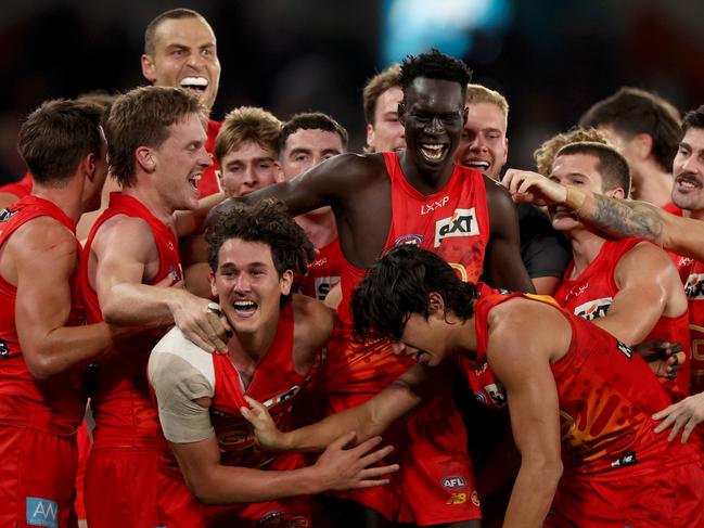 Mac Andrew of the Suns celebrates the match winning goal with teammates after the siren against Essendon. Picture: Jonathan DiMaggio/Getty Images.