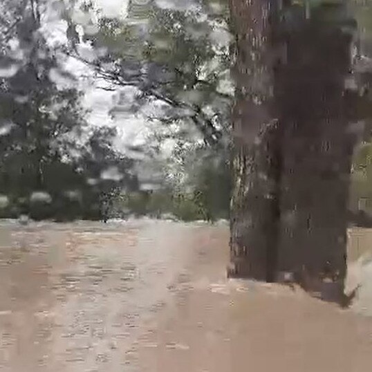 The Triton is pushed off the road into the raging floodwaters.