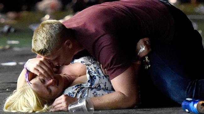 A man lays on top of a woman as others flee the Route 91 Harvest country music festival grounds after a active shooter was reported on October 1, 2017 in Las Vegas, Nevada. A gunman has opened fire on a music festival in Las Vegas, leaving at least 2 people dead. Police have confirmed that one suspect has been shot. The investigation is ongoing. The photographer witnessed the man help the woman up and they walked away. Injuries are unknown.  Picture: Getty Images