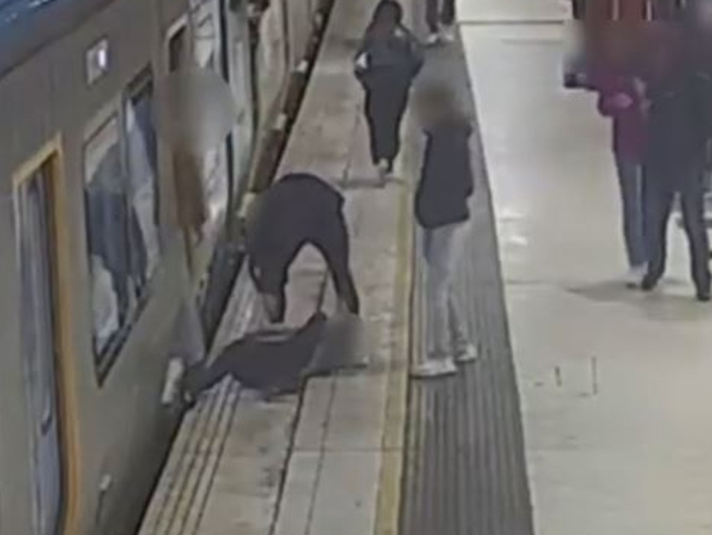 A passenger slips trying to catch a train at Flinders St station.