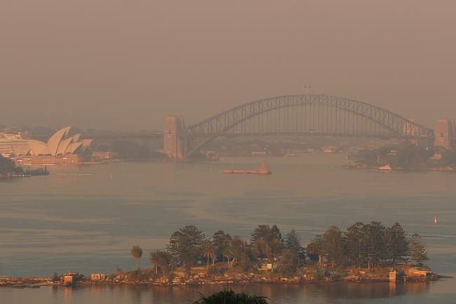 The Sydney basin is filled with smoke at dawn, as seen from Vaucluse. Picture: John Grainger