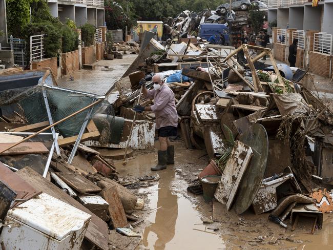 A resident cleans the entrance to his home in Alfafar municipality, in Valencia, Spain. Picture: Getty Images