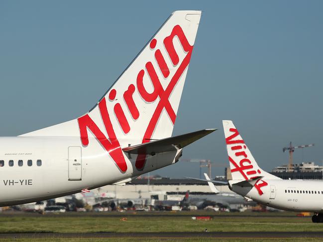 The Virgin Australia Holdings Ltd. logo is displayed on the tails of a Boeing Co. 737-800, left, and a Boeing Co. 737-8FE aircraft preparing to take off at Sydney Airport in Sydney, Australia, on Monday, Feb. 8, 2016. Virgin Australia is scheduled to announce half-year earnings on Feb. 11. Photographer: Brendon Thorne/Bloomberg