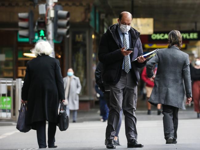 People wear masks on the street in Melbourne. Picture: Ian Currie