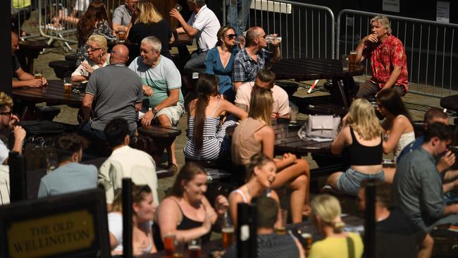 People enjoy themselves at a pub in the centre of Manchester, England as lockdown measures ease. Despite people getting out and about, the death toll and hospital admissions are plunging, leading scientists to believe that the “threshold” for herd immunity may have been lowered because many people may already be immune to the disease without ever having caught it. Picture: AFP