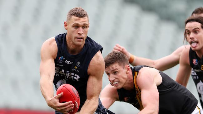 Former Panther Alex Cailotto gets a handball away under pressure from Glenelg’s Jack Hannath. The big utility will provide an option for SHOC around the ground. Picture: Sarah Reed