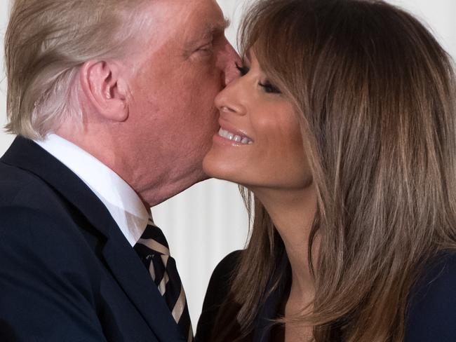 US President Donald Trump embraces First Lady Melania Trump (R). Picture: AFP