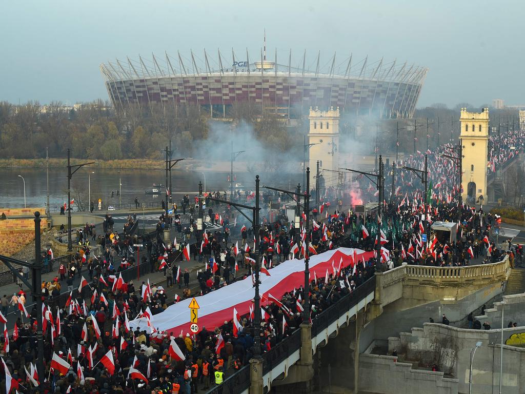 People wave flags during an Independence Day march in Warsaw. Picture: Adam Chelstowski/AFP