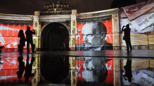 No more heroes: People look at a portrait of Soviet Union founder Vladimir Lenin drawn in light at Dvortsovaya (Palace) Square. Picture: AP