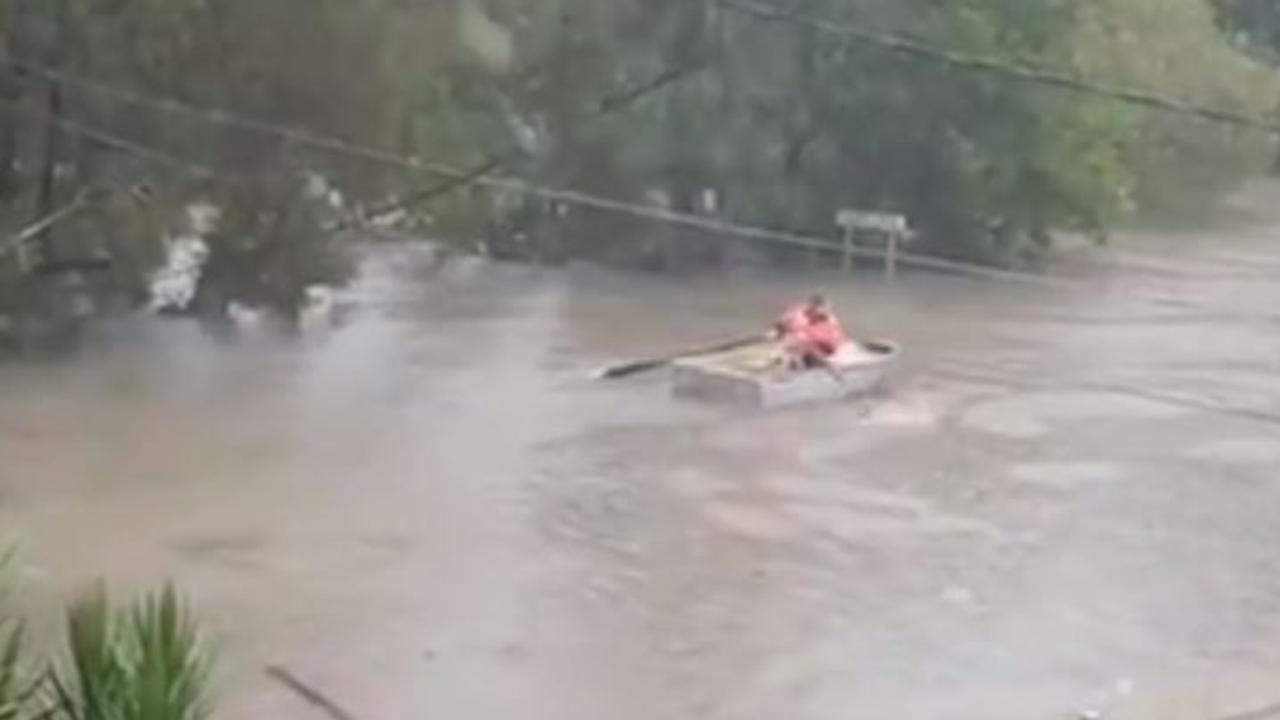 A man rows a boat down a Southport street. Photo: Ricky Ricky Kroesen