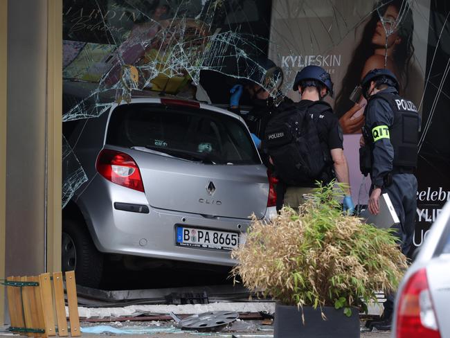 Police investigators stand near a car that plowed into pedestrians and then smashed into a store in Berlin. Picture: Getty Images