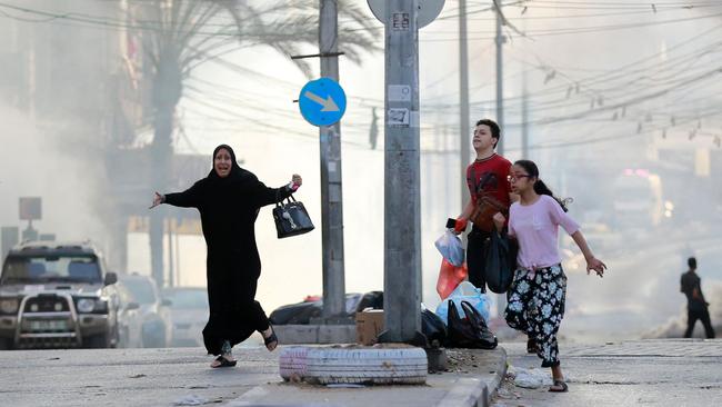 Palestinians run for cover after a strike near the Al-Shifa hospital in Gaza City on Wednesday. Picture: AFP