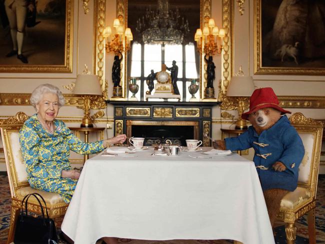TOPSHOT - An undated handout photograph released by Buckingham Palace on June 4, 2022, shows Queen Elizabeth II and Paddington Bear having cream tea at Buckingham Palace, taken from a film that was shown at the BBC Platinum Party at the Palace on June 4, 2022. - Some 22,000 people and millions more at home are expected at a star-studded musical celebration for Queen Elizabeth II's historic Platinum Jubilee. (Photo by BUCKINGHAM PALACE / AFP) / XGTY / RESTRICTED TO EDITORIAL USE - MANDATORY CREDIT 
