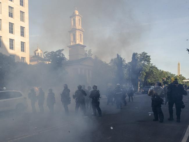 Tear gas floats in the air as a line of police move demonstrators away from St. John's Church across Lafayette Park from the White House. Picture: AP