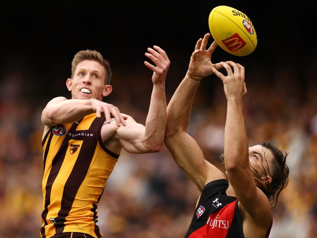 MELBOURNE. 19/03/2023. AFL Round 1. Hawthorn vs Essendon at the MCG. Sam Draper of the Bombers tries to mark behind Sam Frost of the Hawks during the 3rd qtr. . Pic: Michael Klein