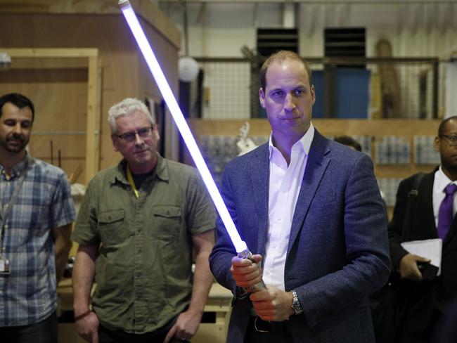 Prince William, Duke of Cambridge holds a lightsaber during a tour of the Star Wars sets at Pinewood studios. Picture: Getty